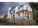 Stunning modern farmhouse exterior with a black-trimmed white facade and a charming wood fence at 3019 Chase St, Wheat Ridge, CO 80214