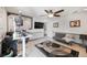 Cozy living room with neutral color scheme, ceiling fan, mounted TV, and adjacent seating area at 4505 S Yosemite St # 433, Denver, CO 80237