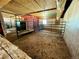 Enclosed stall inside barn with metal gate and hay-covered floor at 1740 Michael Gates Dr, Parker, CO 80138