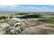 Stunning aerial view of a property with horse arena, outbuildings, pastures, and rolling hills at 1740 Michael Gates Dr, Parker, CO 80138