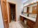 Bathroom featuring double sinks, wood cabinets, and a separate toilet area at 1740 Michael Gates Dr, Parker, CO 80138
