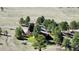 Aerial view showcases the back of a home nestled in a grassy, tree-filled landscape, offering privacy and natural beauty at 1740 Michael Gates Dr, Parker, CO 80138