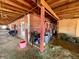 Rustic barn interior with stalls and equipment, featuring hay bales at 1740 Michael Gates Dr, Parker, CO 80138