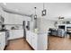 Open kitchen showcases white cabinets, granite countertops, island, and seamlessly connects to the living space at 2889 Windridge Cir, Highlands Ranch, CO 80126