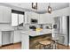 Modern kitchen features white cabinets, stainless steel appliances, and an island with a wooden accent wall at 2889 Windridge Cir, Highlands Ranch, CO 80126