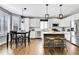 Bright kitchen featuring white cabinets, wood floors, island with bar seating, and stainless steel appliances at 2889 Windridge Cir, Highlands Ranch, CO 80126