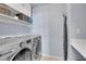 Well-equipped laundry room features modern machines and ample storage shelves for organization at 2889 Windridge Cir, Highlands Ranch, CO 80126