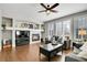 Comfortable living room featuring a cozy fireplace, hardwood floors, and ample natural light from the windows at 2889 Windridge Cir, Highlands Ranch, CO 80126