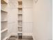 Bright walk-in closet with built-in shelving and hanging rods for optimal organization and storage at 8322 S Upham Way, Littleton, CO 80128