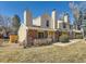 Charming townhouse featuring a brick facade, tan siding, well-maintained lawn, and double chimneys at 8322 S Upham Way, Littleton, CO 80128