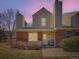 Townhouse exterior displaying brick and siding, set under a dramatic twilight sky, enhancing its curb appeal at 8322 S Upham Way, Littleton, CO 80128