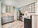 Bright kitchen features two-tone cabinets, stainless steel appliances, and granite countertops at 8322 S Upham Way, Littleton, CO 80128