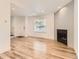 Bright and airy living space featuring hardwood floors, fireplace, and a front door at 8322 S Upham Way, Littleton, CO 80128