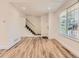 Sunlit living room with hardwood flooring, staircase, and a large window, perfect for relaxing or entertaining at 8322 S Upham Way, Littleton, CO 80128