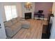Bright living room with fireplace, light wood floors, and comfortable gray sectional sofa at 8322 S Upham Way, Littleton, CO 80128