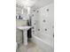 Full bathroom with a white tiled shower/tub combination and a pedestal sink at 1450 Albion St # 206, Denver, CO 80220