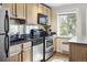 Well-lit kitchen features stainless steel appliances, black granite countertops, and hardwood floors at 1450 Albion St # 206, Denver, CO 80220