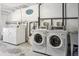 Functional laundry room equipped with modern washing machines and dryers for convenience at 1450 Albion St # 206, Denver, CO 80220