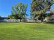 Lush green backyard with mature trees and a wooden fence, ideal for outdoor enjoyment at 1121 W Kettle Ave, Littleton, CO 80120