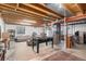 Spacious basement area, features a foosball table, couches, and exposed ceiling beams at 1121 W Kettle Ave, Littleton, CO 80120