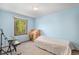 Simple bedroom features a light blue wall, natural lighting, and a twin bed and desk at 1121 W Kettle Ave, Littleton, CO 80120