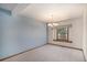 Dining room with chandelier, neutral carpet, and a large window for natural light at 1121 W Kettle Ave, Littleton, CO 80120