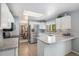 Bright kitchen with stainless steel appliances, white cabinets, and a view of the dining area at 1121 W Kettle Ave, Littleton, CO 80120