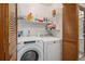 Laundry room with a washer, dryer, shelving for storage, and bi-fold doors at 1121 W Kettle Ave, Littleton, CO 80120