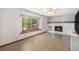 Bright living room features a white brick fireplace, large windows, and hardwood flooring at 1121 W Kettle Ave, Littleton, CO 80120