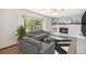 Bright living room featuring a cozy fireplace, plush gray sofas, and large window with natural light at 1121 W Kettle Ave, Littleton, CO 80120