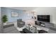 Bright living room featuring a modern entertainment center and an open concept into the dining area at 1121 W Kettle Ave, Littleton, CO 80120