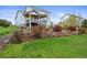 Landscaped backyard with a stone retaining wall and lush green lawn at 42225 Kingsmill Cir, Elizabeth, CO 80107