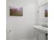 Bright bathroom featuring a pedestal sink, modern fixtures, and artwork at 42225 Kingsmill Cir, Elizabeth, CO 80107