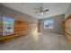 Bedroom with wood floors, ceiling fan, with natural light, and wood paneled wall at 42225 Kingsmill Cir, Elizabeth, CO 80107