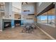 Bright living room with a fireplace, high ceilings, and large windows overlooking the outdoors at 42225 Kingsmill Cir, Elizabeth, CO 80107