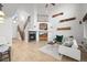 Open living room showcasing plank flooring, fireplace, staircase and vaulted ceiling at 42225 Kingsmill Cir, Elizabeth, CO 80107