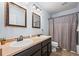 Bathroom with double sinks and a coordinated shower curtain, offering a practical and neat design at 4797 Longs Peak St, Brighton, CO 80601