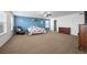 Bright bedroom with blue accent wall featuring plush carpeting, a ceiling fan, and plenty of natural light at 4797 Longs Peak St, Brighton, CO 80601