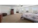 Large bedroom with neutral carpeting, ample windows, and a view into a separate sitting area at 4797 Longs Peak St, Brighton, CO 80601
