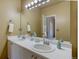 Bathroom features a double vanity with a large mirror and modern lighting at 9659 Autumnwood Pl, Highlands Ranch, CO 80129