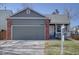 Charming single-Gathering home featuring a grey facade, brick accents, and a two-car garage at 9659 Autumnwood Pl, Highlands Ranch, CO 80129