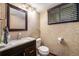 Cozy bathroom with modern vanity, stylish wallpaper, and natural light from window at 17595 E Wesley Pl, Aurora, CO 80013