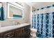 Modern bathroom with a dark vanity, lighted mirror, and shower with a stylish blue curtain at 17595 E Wesley Pl, Aurora, CO 80013