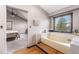 Bright bathroom showcasing a soaking tub and separate vanity with wood floors at 17595 E Wesley Pl, Aurora, CO 80013