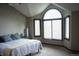 Bright primary bedroom with a large arched window and neutral color scheme with ample sunlight at 17595 E Wesley Pl, Aurora, CO 80013
