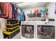 Functional laundry room with washer, dryer, storage bins, and shelving at 17595 E Wesley Pl, Aurora, CO 80013