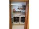 Enclosed laundry room featuring a side-by-side washer and dryer and shelf storage at 17595 E Wesley Pl, Aurora, CO 80013