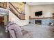 Cozy living room featuring a fireplace with decorative stonework and a staircase leading upstairs at 17595 E Wesley Pl, Aurora, CO 80013