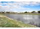 Scenic pond view in a residential neighborhood with lush green grass and a walking path, providing a serene environment at 17595 E Wesley Pl, Aurora, CO 80013