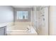 Bathroom featuring a tub and shower with glass door at 1936 E 144Th Dr, Thornton, CO 80602